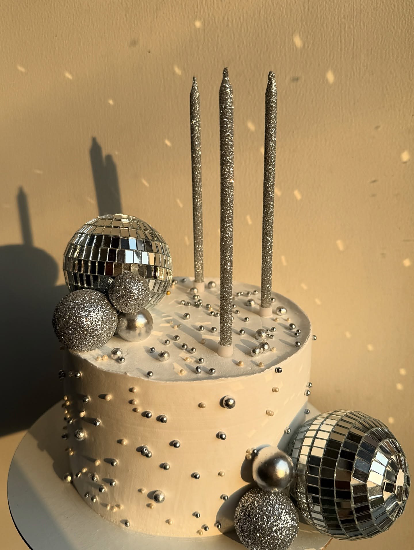 Silver disco ball celebration cake with tall candles